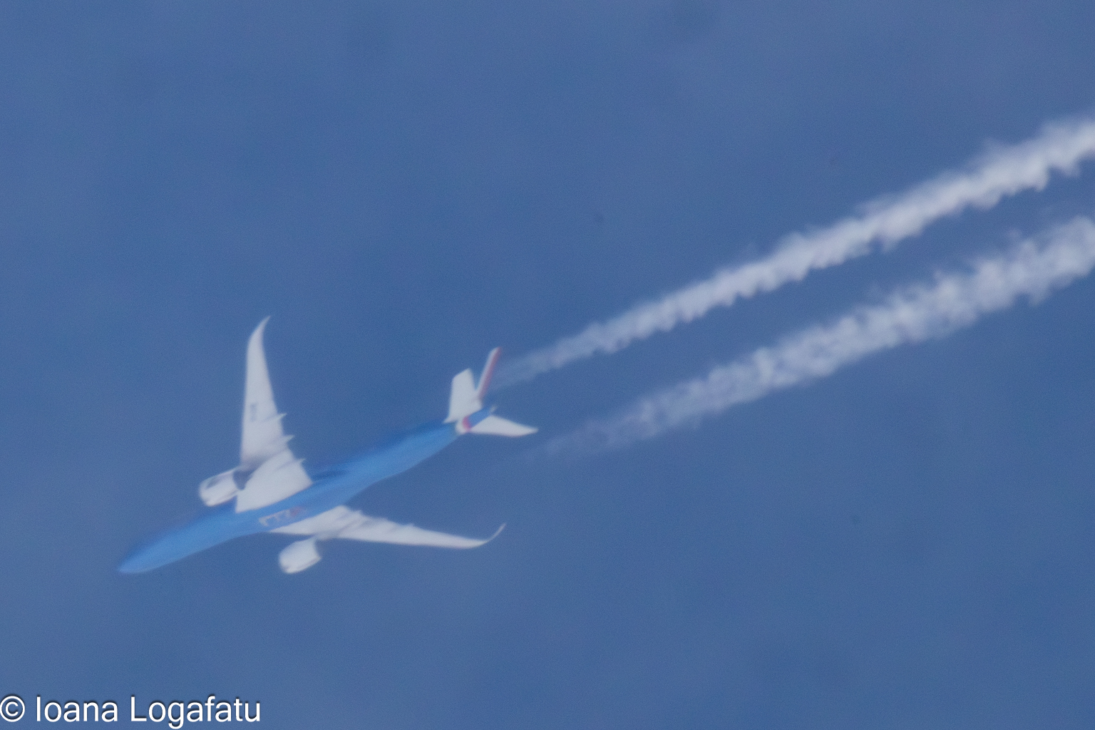 A plane leaves trails high in the sky